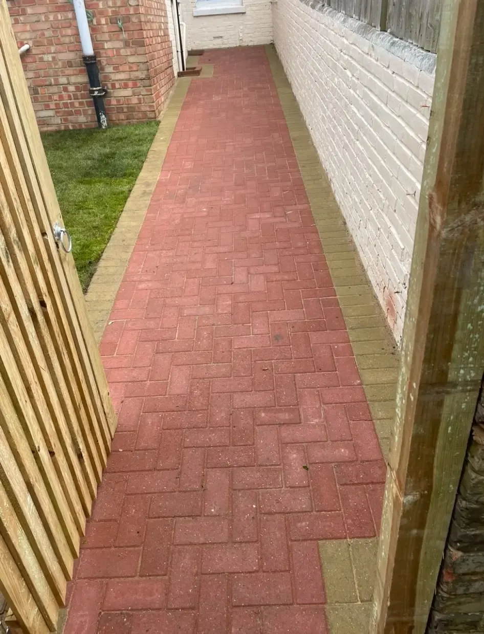 Red block paving pathway installation with contrasting border